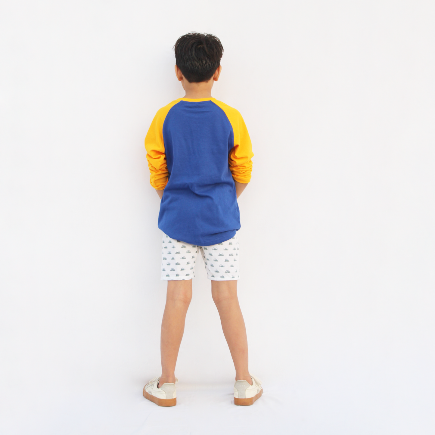 Boy wearing blue yellow raglan tshirt playing outdoor