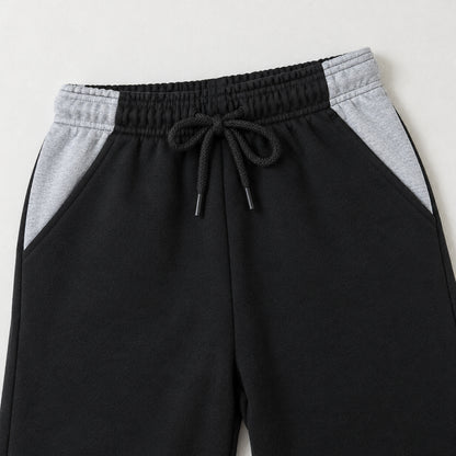 Kids black fleece trousers featuring two grey contrast side pockets and an elasticated drawstring waistband for boys and girls.