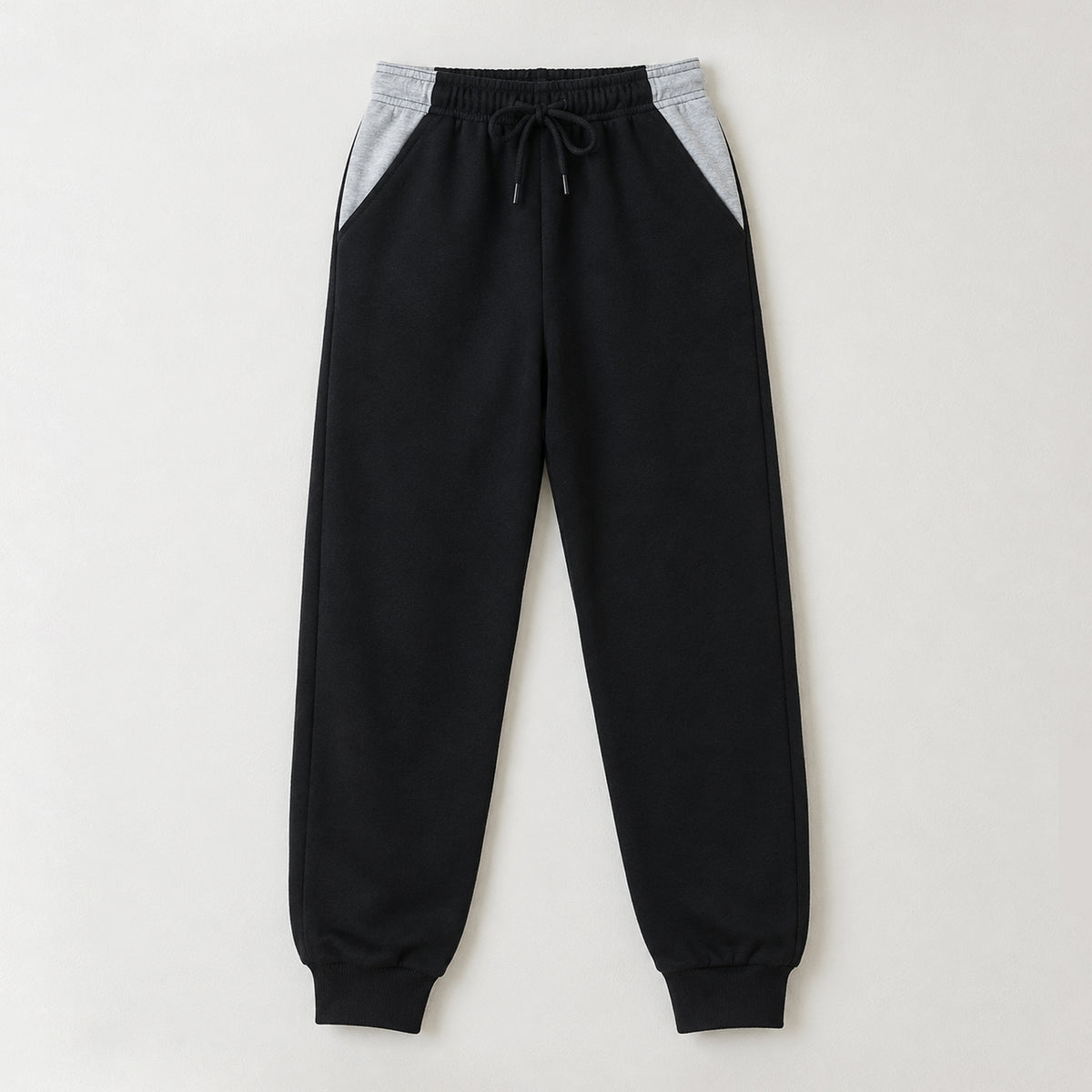 Black fleece trousers for boys and girls with grey contrast side panels, elasticated waistband, drawstring, and ribbed ankle cuffs by The Shop.